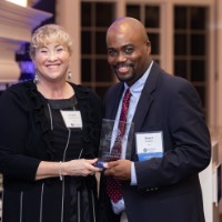 Quincy Williams showing award with woman